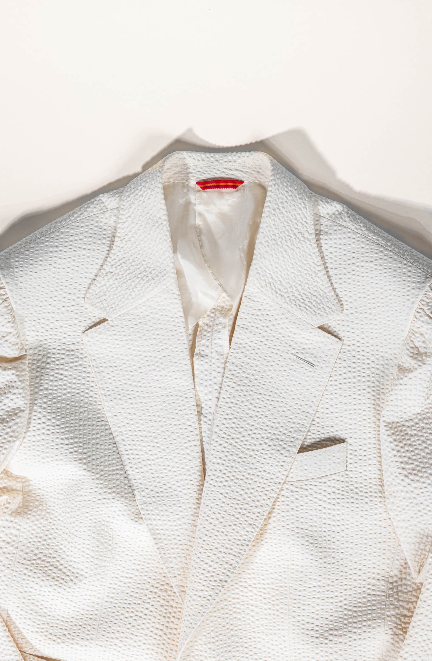 White textured blazer on a white background