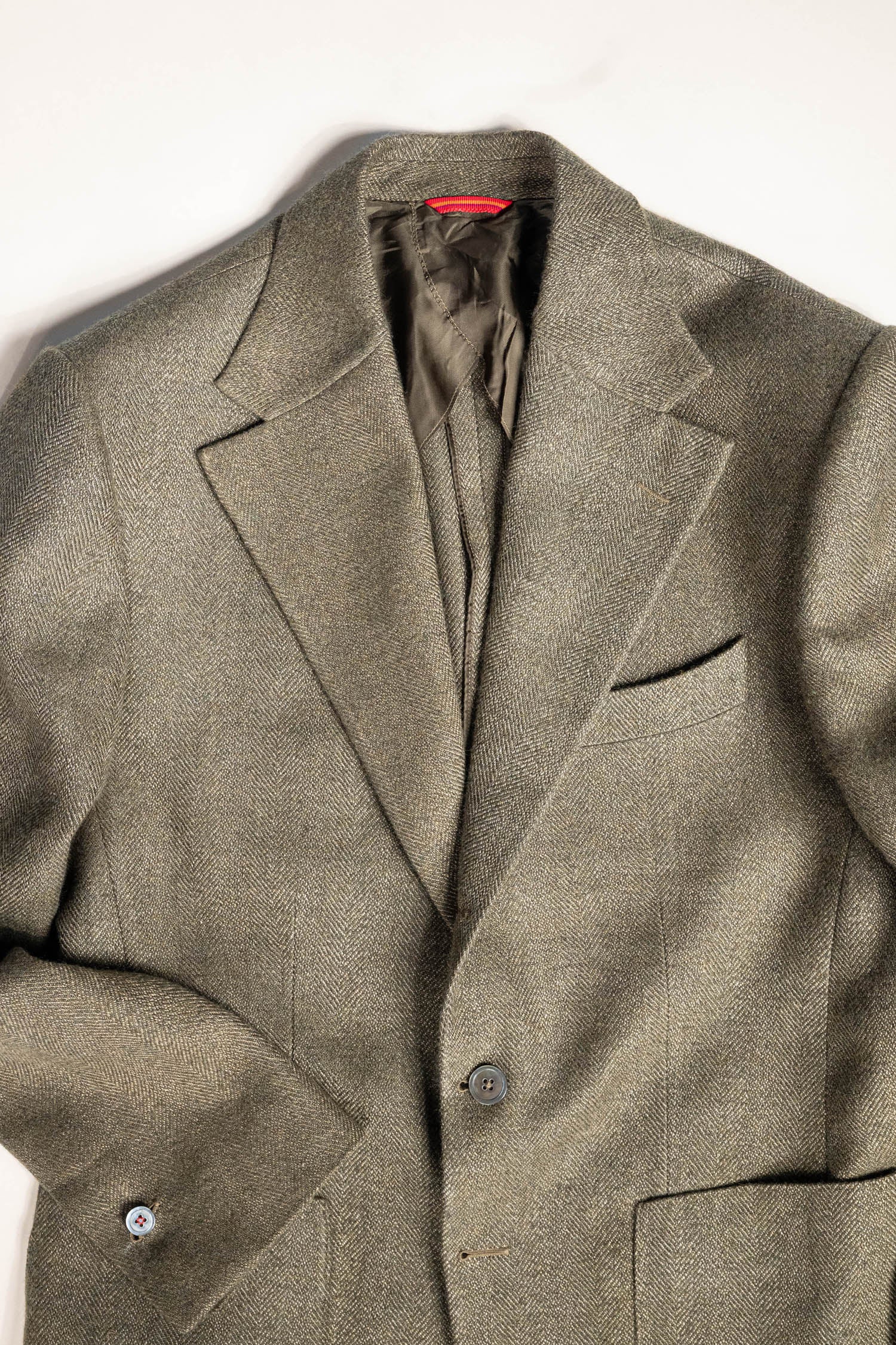 Refined menswear by Osman Abdul Razak olive herringbone jacket unpadded through the shoulder for ease