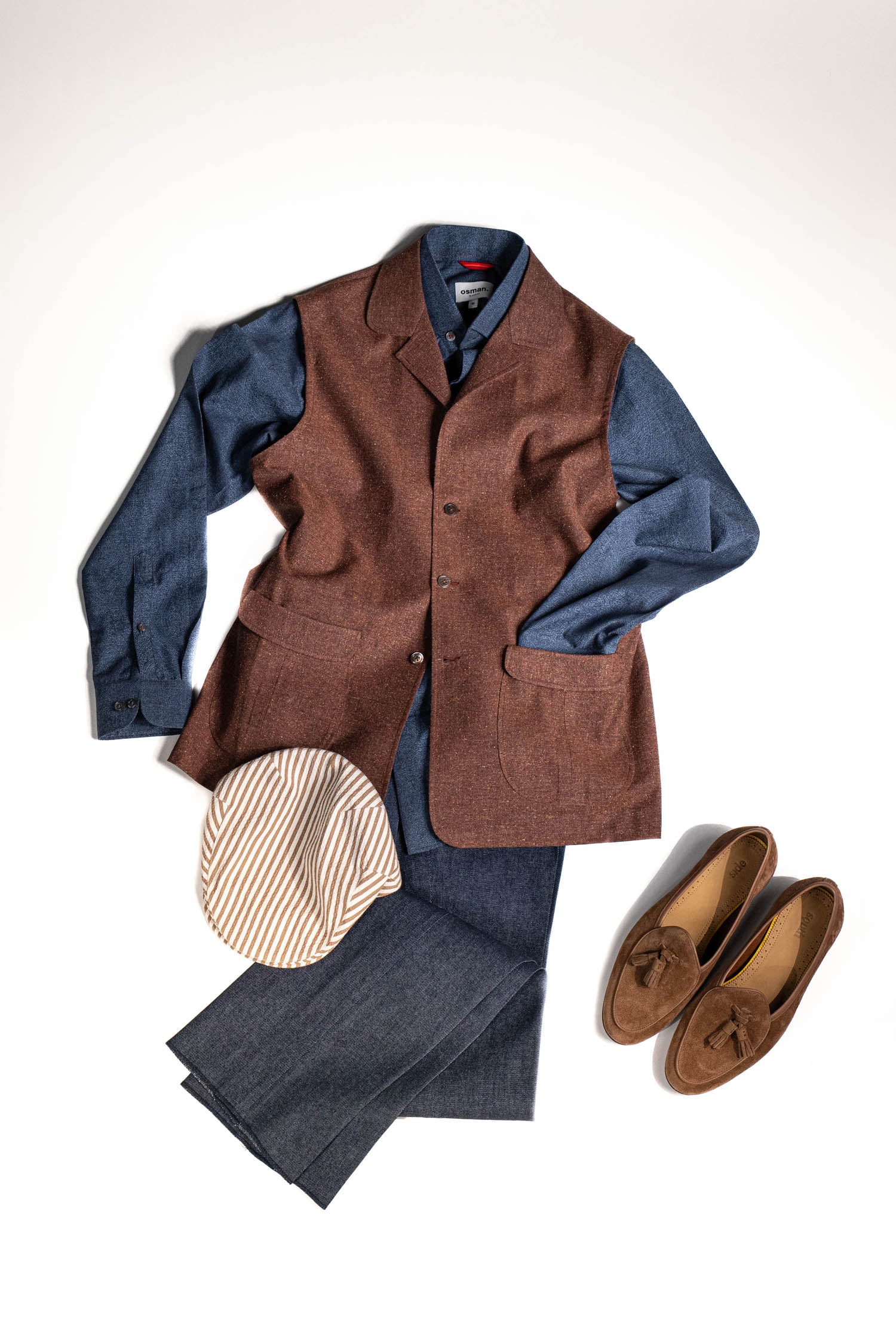Tailored menswear by Osman Abdul Razak – earthy rust gilet for refined layering with sculpted silhouette