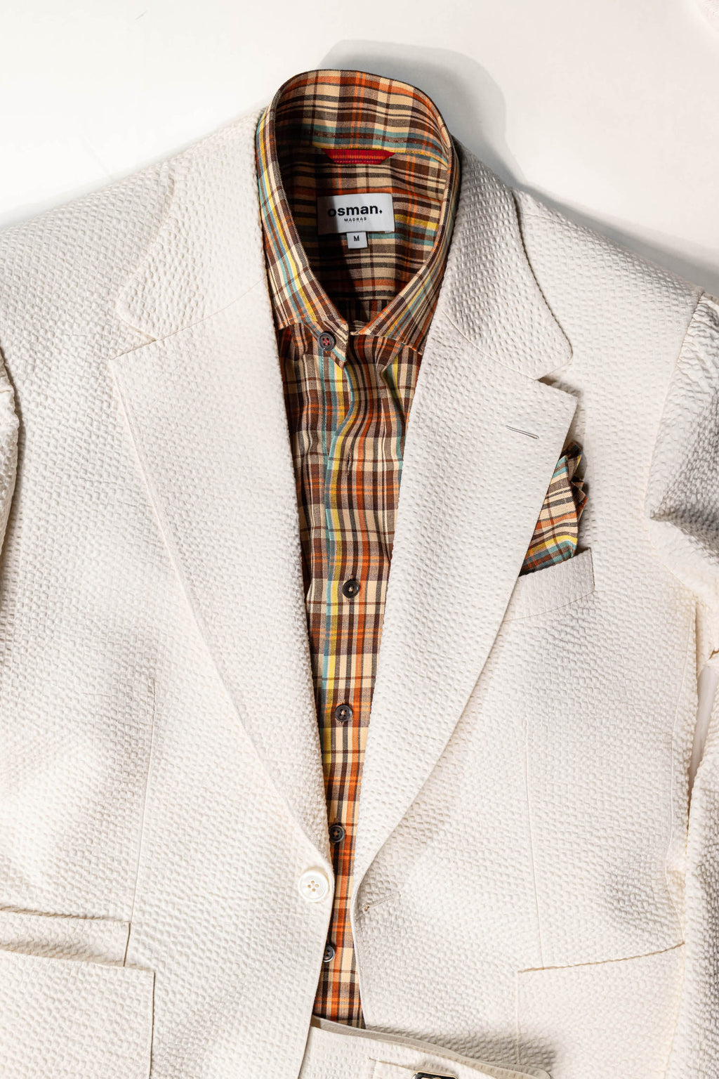 White blazer with plaid shirt on a white background