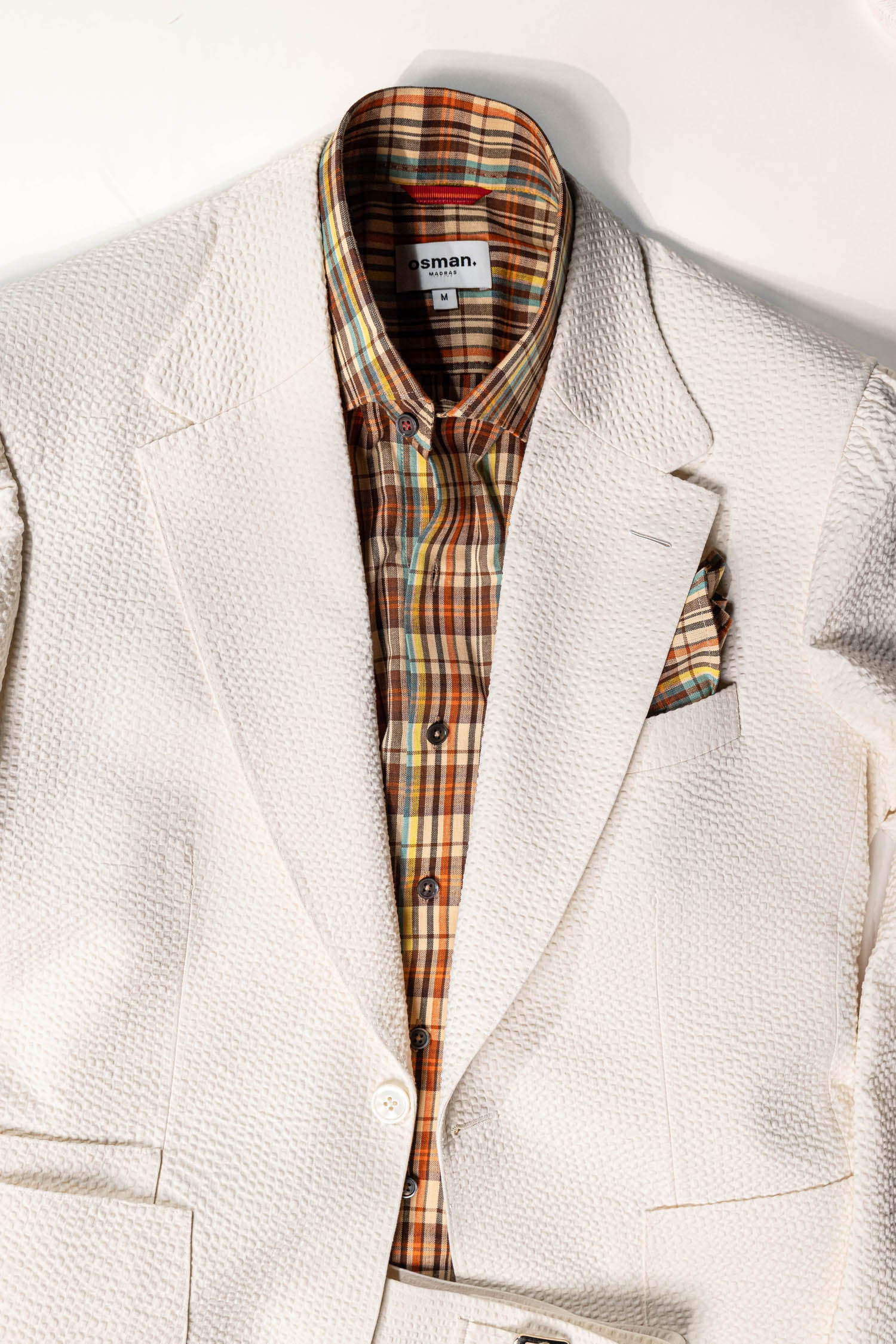 White blazer with plaid shirt on a white background